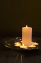 Vertical image. Candles and candlelights. Golden salver and candles on it against brown background