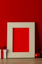 Vertical image of chrsitmas decorations and wooden frame with copy space on red background