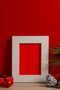 Vertical image of chrsitmas decorations and wooden frame with copy space on red background