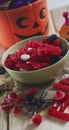 Vertical image of close of candy and halloween pumpkin basket with sweets on rustic background