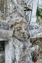 Vertical image. Closeup view of unnamed gravestone on old abandoned city cemetery. Weathered stone crucifix cross on Royalty Free Stock Photo