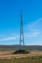 Vertical image of an electricity pylon on empty agricultural field Royalty Free Stock Photo