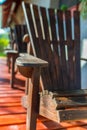 Vertical image, empty adirondack arm chairs in row on wood deck