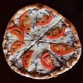 Vertical image Flat-lay of Lebanese meat and cheese pizza pie dish Lahme Bi Ajeen with fresh tomatoes taken from above on a Royalty Free Stock Photo