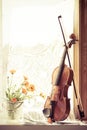 Vertical image of flowers and violin with sheet music  the front of the fiddle on windows background Royalty Free Stock Photo