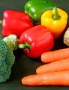 Vertical image of fresh colorful vegetables scattered on black wooden table Royalty Free Stock Photo