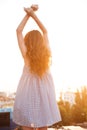 Vertical image of a ginger woman posing back