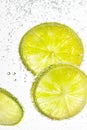 Vertical image of green lime slices in a fizzy drink Royalty Free Stock Photo