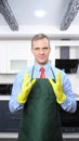 A vertical image. handsome man in tie and apron wearing rubber gloves