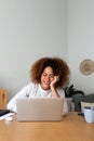 Vertical image of happy african american woman working at home office. Multiracial female entrepreneur using laptop Royalty Free Stock Photo