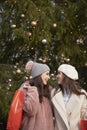 Vertical image of women and big Christmas tree Royalty Free Stock Photo