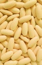Vertical image of heap of creamy yellow oval shaped supplement pills