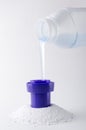 Vertical image.Heap of laundry detergent and bottle of liquid one, white background