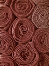 Vertical image of Heap of rolled up red brown blankets for background