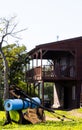 Vertical image of hiking poles, shoes and backpack with mat over log cabin on sunny day Royalty Free Stock Photo