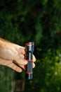 Vertical image of male hand holding new mini LED Stier flashlight torch Royalty Free Stock Photo