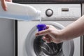 Household chores. Laundry detergnet puring into the cup against washing machine Royalty Free Stock Photo