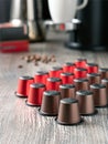Vertical image of many multi-colored capsules for a coffee machine lie on a beautiful wooden table against the background of the Royalty Free Stock Photo