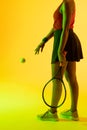 Vertical image of midsection of african american female tennis player in yellow lighting