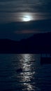 Vertical image of moonpath over the sea waves. Moon shining and reflecting on ocean surface