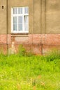 Vertical image of an old building with grungy brick wall and broken window Royalty Free Stock Photo