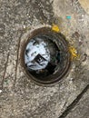 Vertical image, opened missing sewage cover, the manhole  filled with human trash Royalty Free Stock Photo