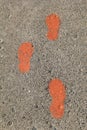 Vertical image of painted foot prints on cement background