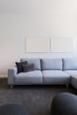 Vertical image of pastel blue sofa with blank artwork above Royalty Free Stock Photo