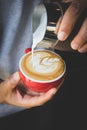 Vertical image of pouring milk to espresso coffee make latte art