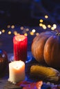 Vertical image of pumpkins, corn cob and candles with copy space on dark background Royalty Free Stock Photo