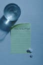 Vertical image.Sheet of paper, pills, glass of water.Night time.Empty space for text Royalty Free Stock Photo