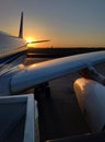 Vertical image, Silhouette of a passenger airplane landing on the airport apron against the backdrop of the picturesque orange Royalty Free Stock Photo