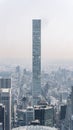 Vertical image of a sleek skinny skyscraper in midtown Manhattan with clear sky