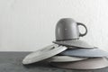 Closeup of stack clean and wet plates, cup on the grey table against white wall.Empty space Royalty Free Stock Photo