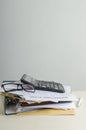 Vertical image. Stack of office documents and blank market plan, glasses, calculator on the work desk against white wall.Empty spa Royalty Free Stock Photo