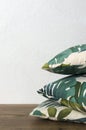 Vertical image.Stack of pillows with floral ornament on the brown floor against white wall.Empty space