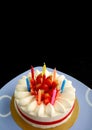 Vertical Image of Strawberry Vanilla Short Cake with Multi-color Candles Preparing for the Celebration on Black Background