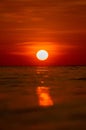 Vertical image of a sun above a water surface during a golden hour Royalty Free Stock Photo