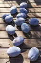 Vertical image.Tasty rope plums on the wooden table.Natural sun light