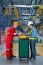 Vertical image of technician and engineer workers discuss about tools and equipment with cabinet in front of railroad tracks of