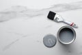 Top view of opened can of grey paint and brush on the marble floor.Empty space Royalty Free Stock Photo