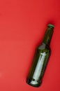 Vertical image.Top view of one bottle of beer on the brigth red background.Cold and fresh beverage Royalty Free Stock Photo