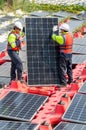 Vertical image of two professional technician workers stand and hold solar cell panel to check and maintenance the system in Royalty Free Stock Photo