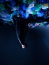 Vertical image upside down of a artistic picture of a young man in studio, surrounded by empty plastic garbage bags Royalty Free Stock Photo