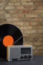 Vertical  image.Vintage vinyl record and radio player on the dark surface against brick wall Royalty Free Stock Photo