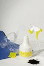 Vertical image.White plastic sprayer, protective glasses, heap of ground on the white, blue background.Creative set of gardening t Royalty Free Stock Photo