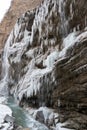 Vertical image of winter river and rozen icicles of big waterfall.