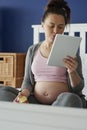 Vertical image of woman using tablet while sitting in bed Royalty Free Stock Photo