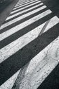 Vertical image of a worn pedestrian zebra crossing painted on an asphalt road surface Royalty Free Stock Photo