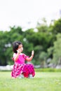 Vertical image. A young girl is stumped alone after losing a soccer match, a child sits on a soccer ball.